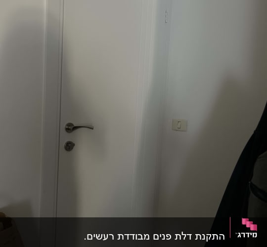 דלת לבנה עם ידית מתכת, קיר לבן